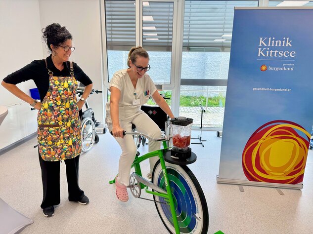 Foto: Gesundheit Burgenland Eine Frau am Rad mit einem Smoothieaufsatz, eine Frau steht daneben