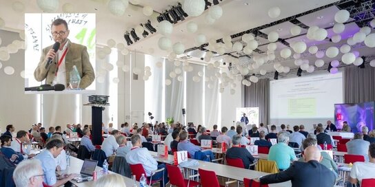 Blick auf die Gäste bei einem Vortrag beim Hüft-Kongress, links oben ein Bild von ÄD OA Dr. Werner Maurer-Ertl