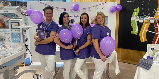 Vier Mitarbeiterinnen in der Klinik Oberwart am Stand mit violetten Luftballons