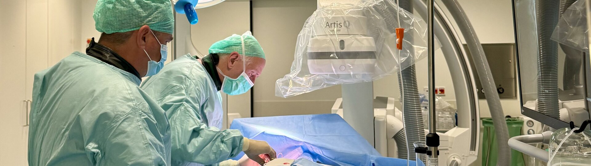 Innere Medizin: zwei Ärzte bei der Untersuchung/OP mit Schutzausrüstung