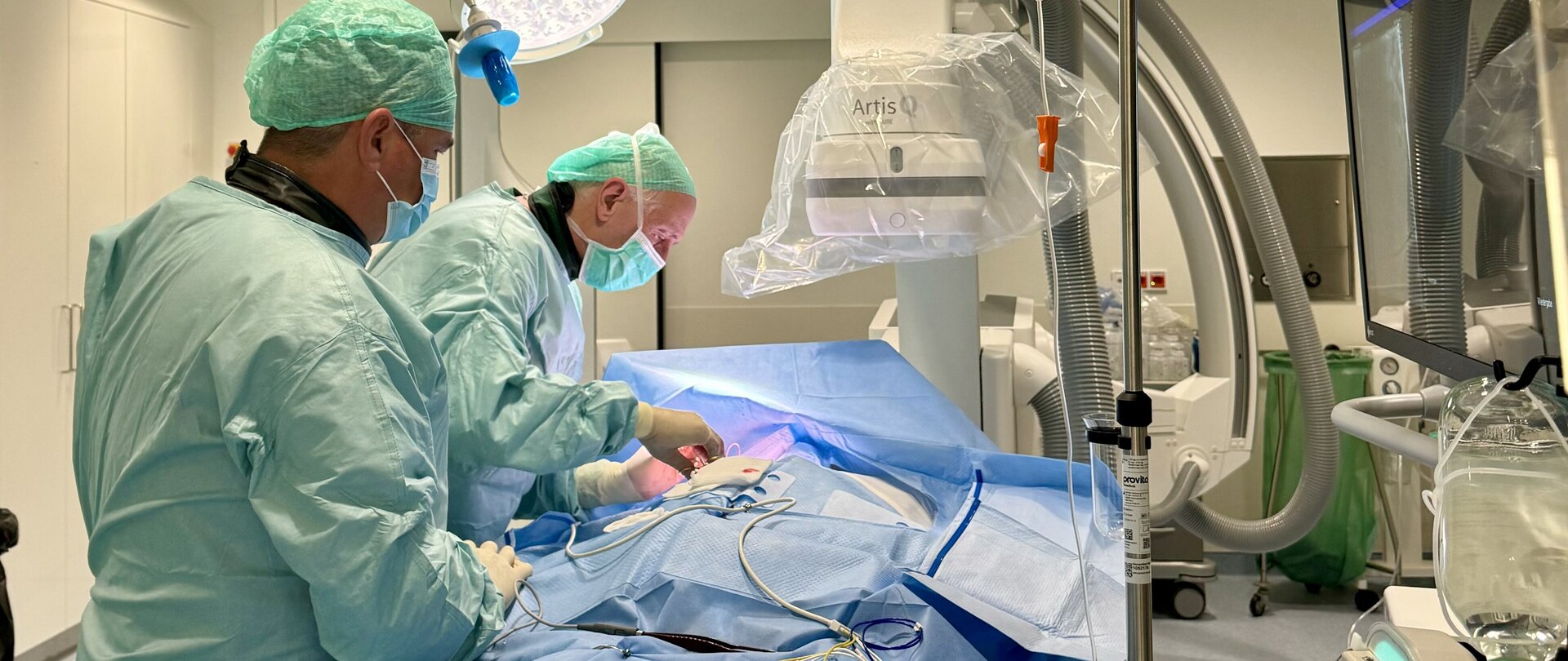 Innere Medizin: zwei Ärzte bei der Untersuchung/OP mit Schutzausrüstung