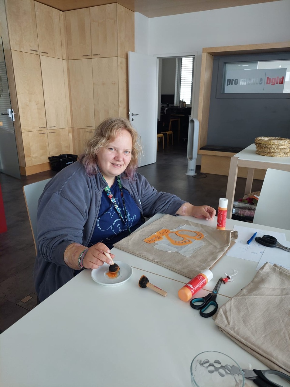 Foto: pro mente Burgenland Eine Frau bestempelt Sackerl mit Babyfüßen