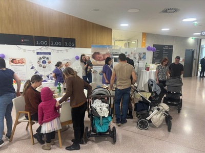 Mehrere Menschen plus Kinderwägen bei einem Infostand