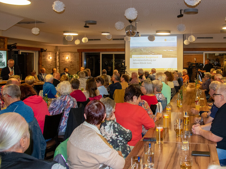 Foto: Landesmedienservice Burgenland Menschen, die an Tischen sitzen bei einer Infoveranstaltung