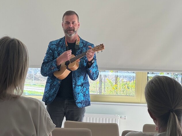 Foto: Gesundheit Burgenland Ein Mann spielt Gitarre, zwei hören zu