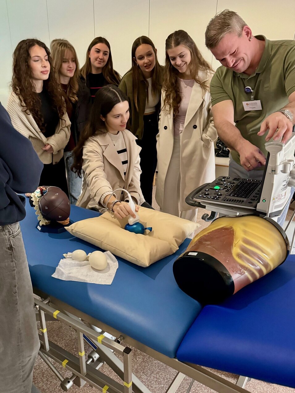 Hochschullehrer Florian Pichler, MSc erklärt Schülerinnen den Ultraschall