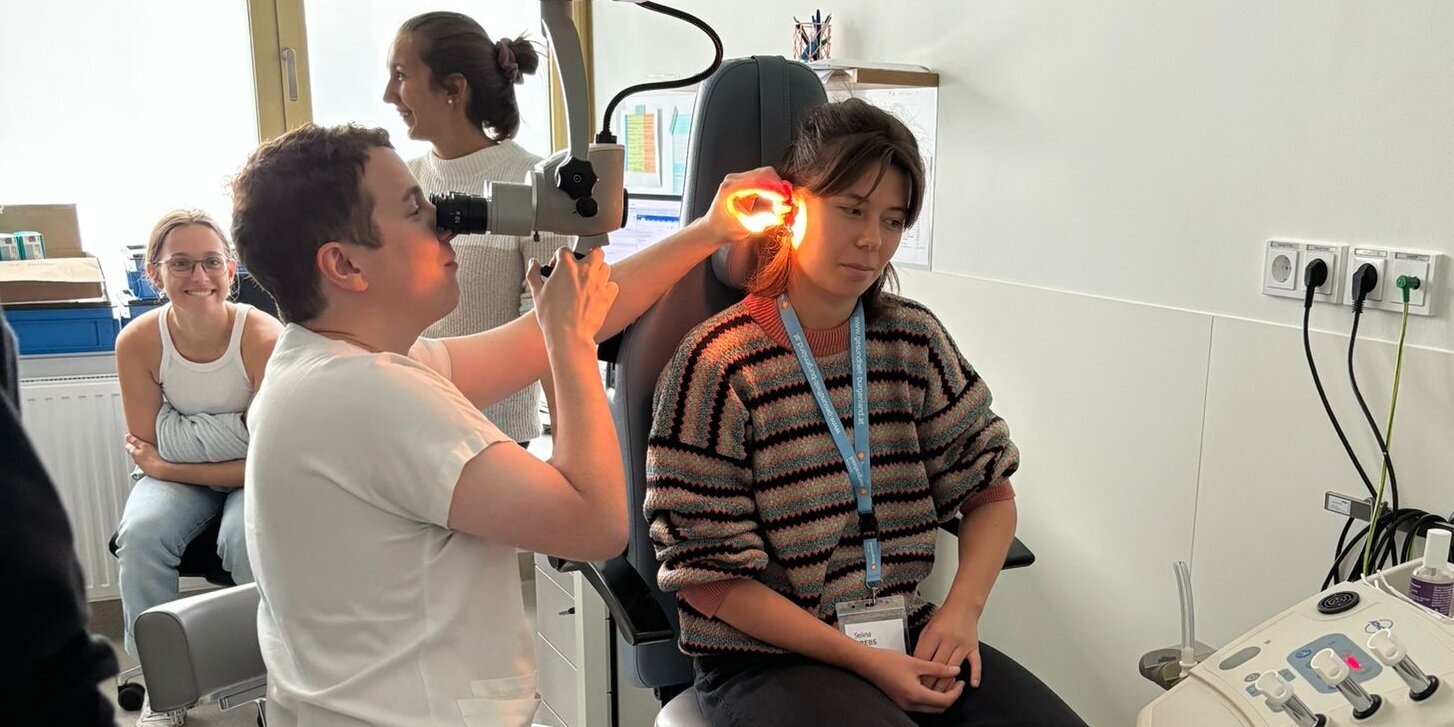 Arzt zeigt im Rahmen der Summer School eine Untersuchung am Ohr