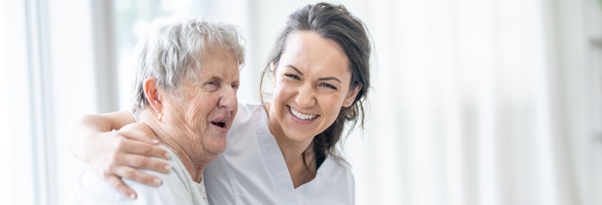 Pflegepersonal umarmt Patientin 