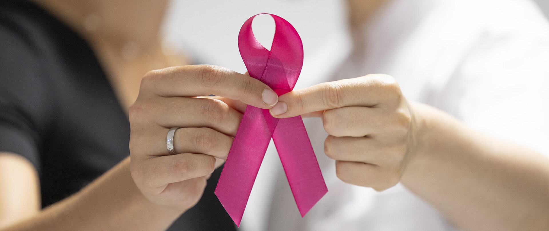 Foto: Gesundheit Burgenland/Muik Zwei Hände halten eine rosa Schleife