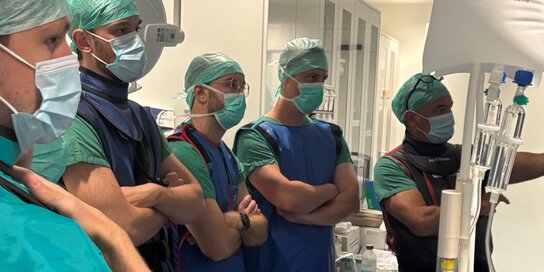 Mehrere Menschen stehen in OP-Kleidung