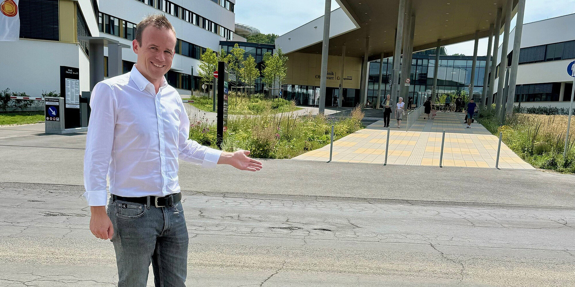 Marc Seper zeigt vor der Klinik Oberwart auf die Stelle, wo der Fußgängerübergang hinkommen soll