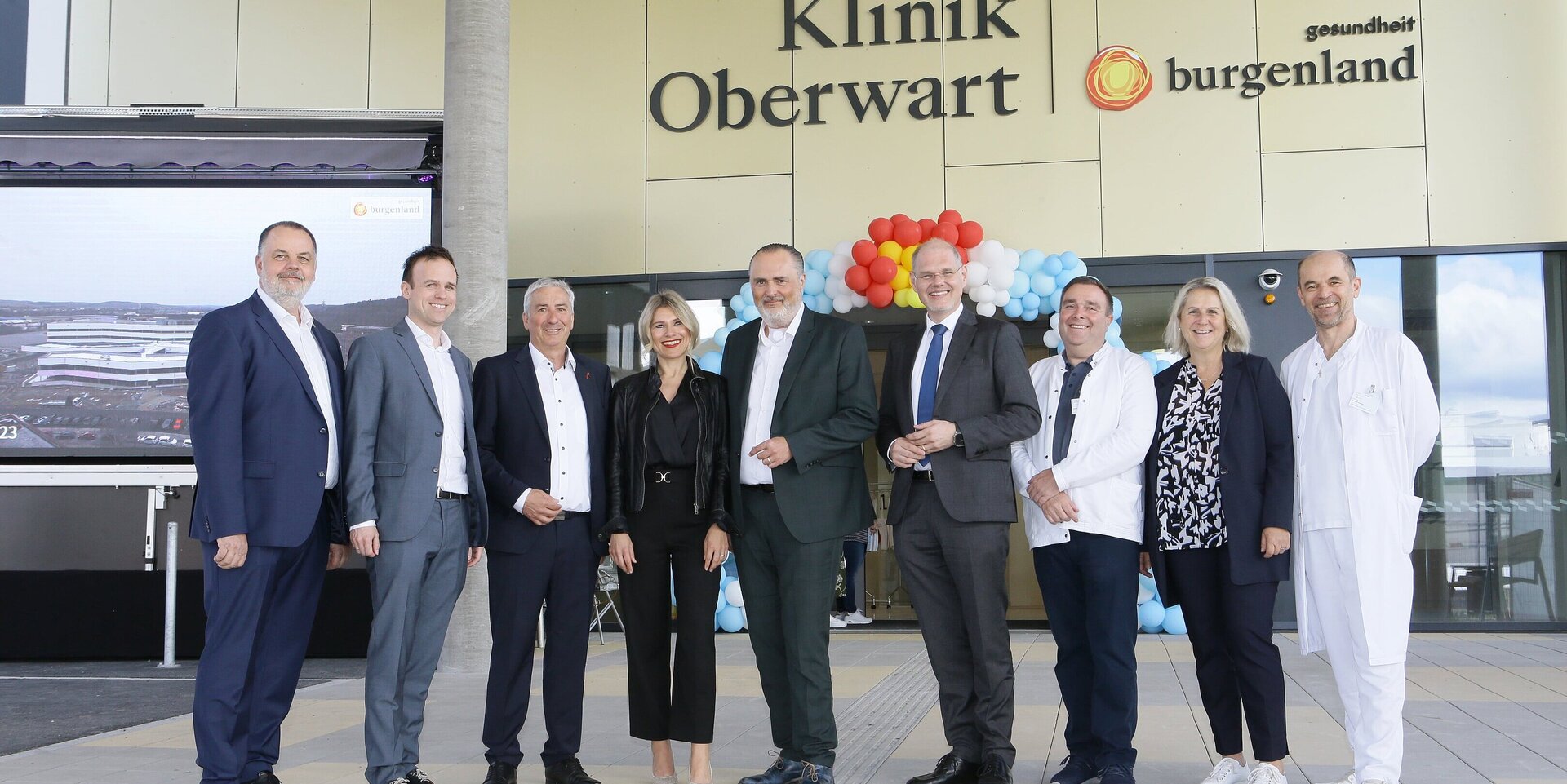 Vor dem Eingangsportal: Andreas Schmidt (Pflegedirektor Klinik Oberwart), Marc Seper (kaufm. Direktor), Michael Leitgeb (Vizebürgermeister Oberwart), Julia Doskozil, Landeshauptmann Hans Peter Doskozil, Franz Öller (kaufm. Geschäftsführer), Dietmar Ochsenhofer (Betriebsratsvorsitzender), Evelyne Gräf (ärztliche Direktorin), Herbert Gruber (ärztlicher Direktor)