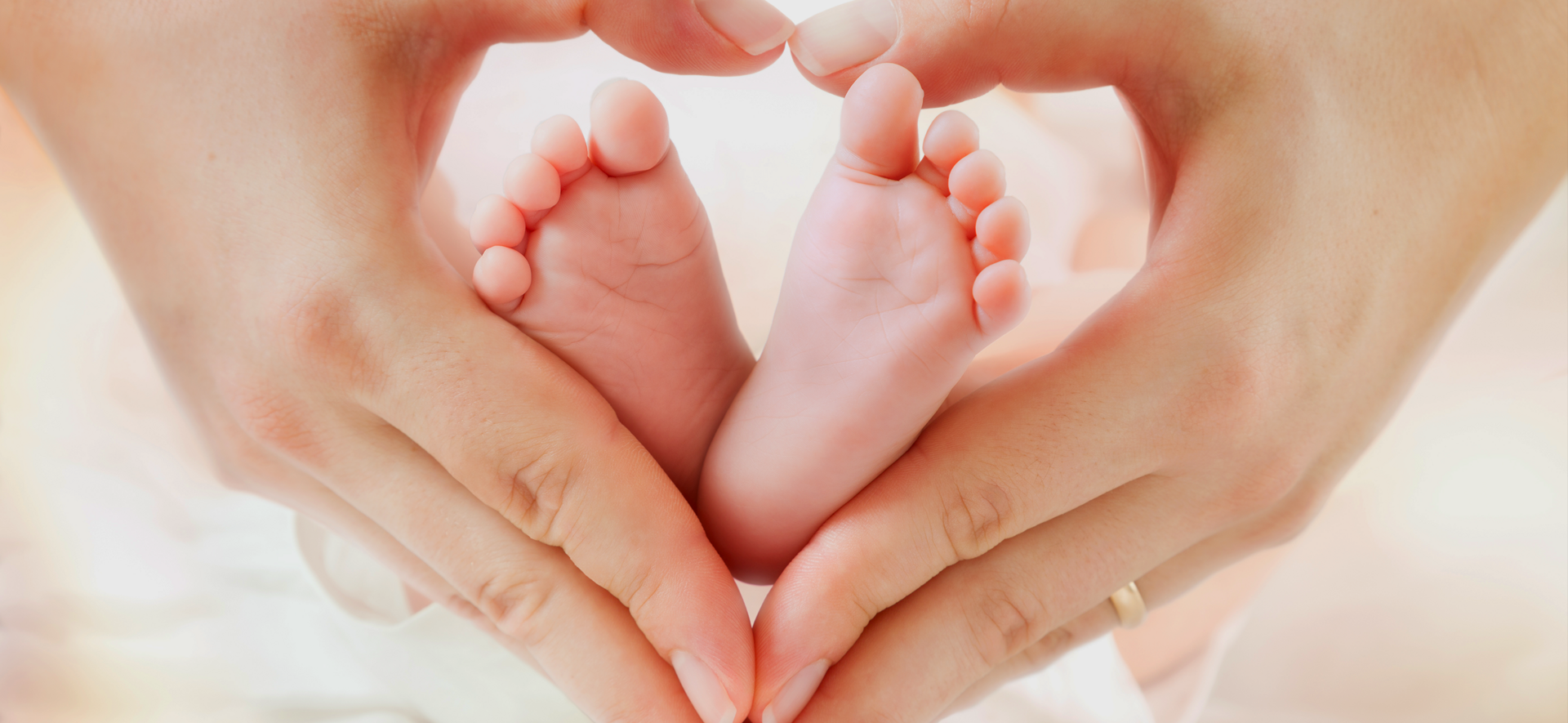 Baby-Füße in Herz geformte Hände