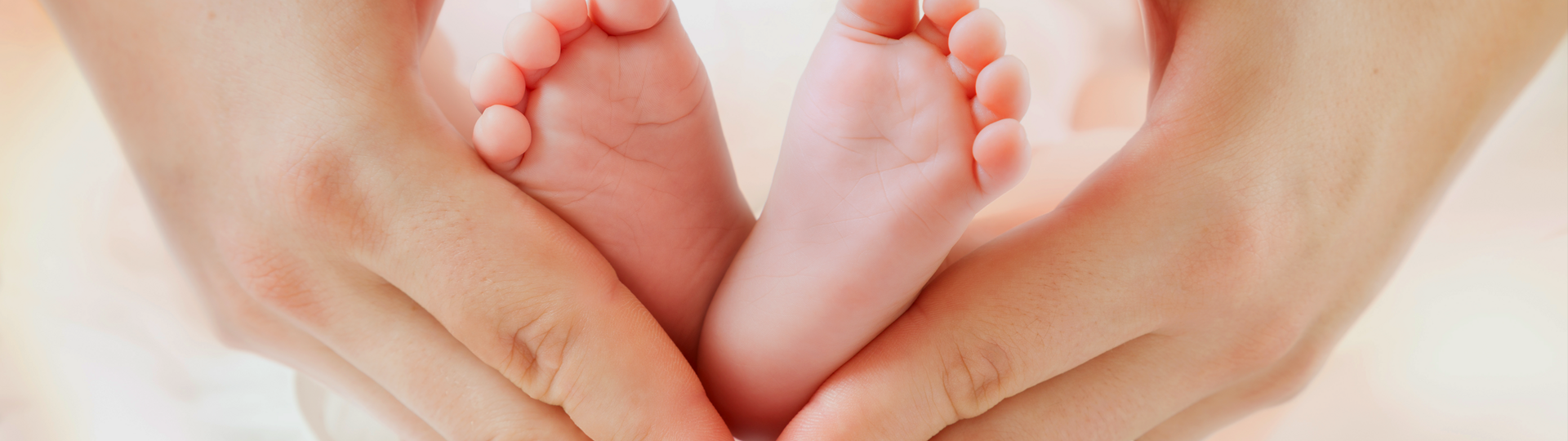 Baby-Füße in Herz geformte Hände