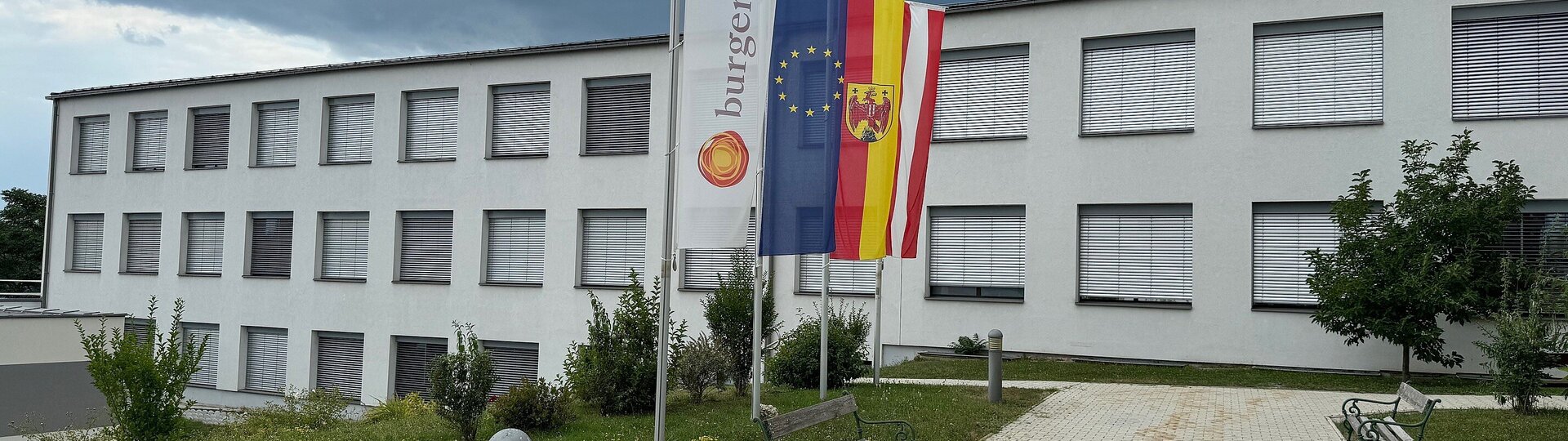 Das Gebäude der Klinik Oberpullendorf von außen mit Fahnen davor