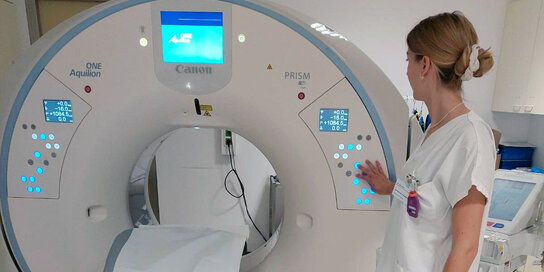 Eine Frau in Weiß steht nehmen einem MR-Gerät