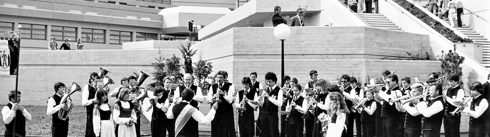 Altes Foto von Klinik Oberwart früher mit Blaskapelle im Vordergrund und Gebäude im Hintergrund (schwarz/weiß)