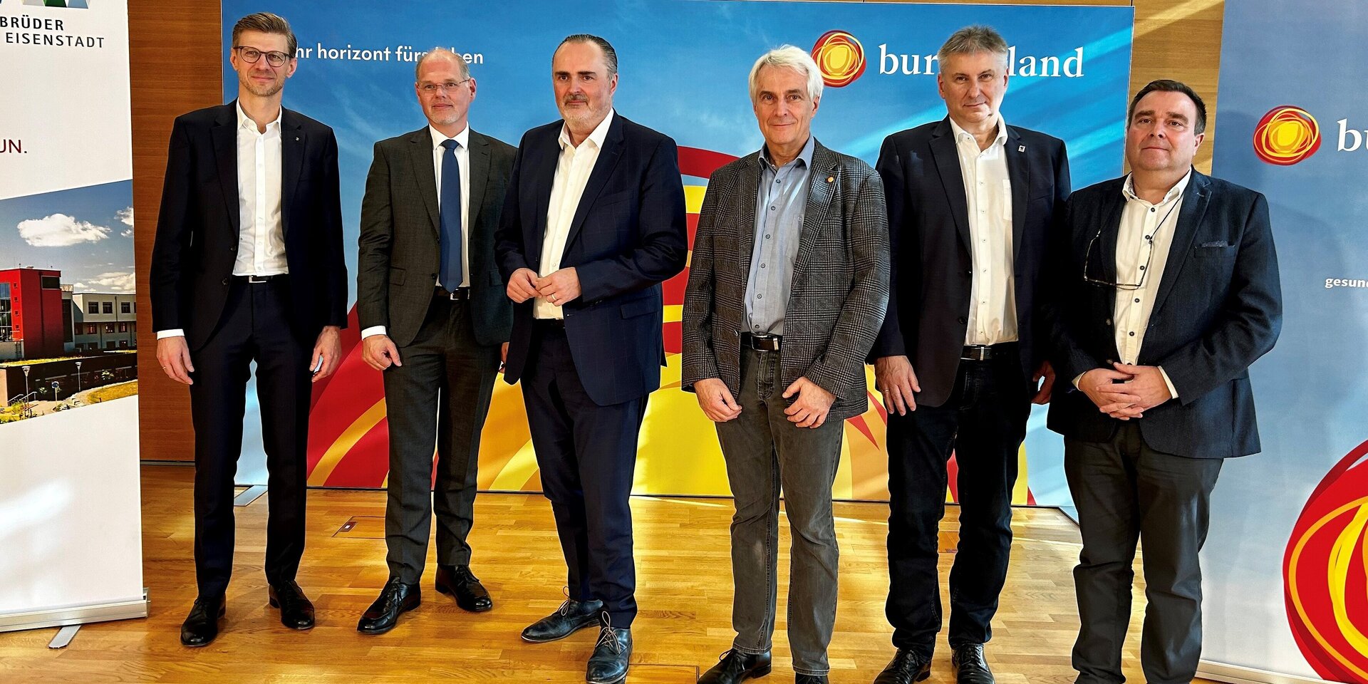 Mehrere Männer stehen bei einer Pressekonferenz vor dem Sujet der Gesundheit Burgenland